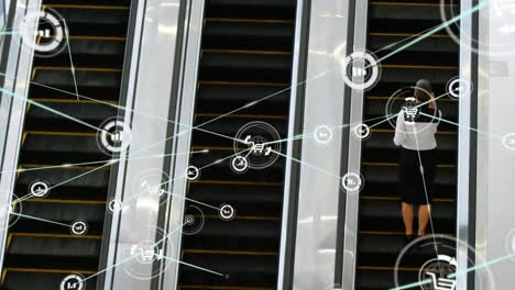 Animation-of-network-of-connection-with-icons-over-diverse-businesswoman-on-escalator-in-office