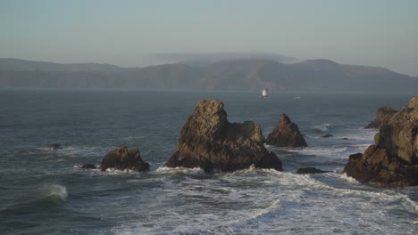 waves crash into the rocky shores of the pacific coast in san francisco, california