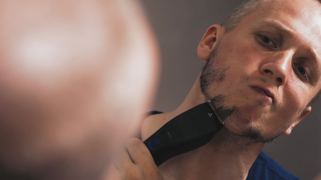 클로즈업 남자는 거울에 자신을  ⁇ 고 시작합니다.