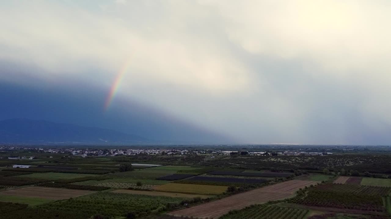 arco iris colorido detrás del cielo nublado sobre el pueblo rural