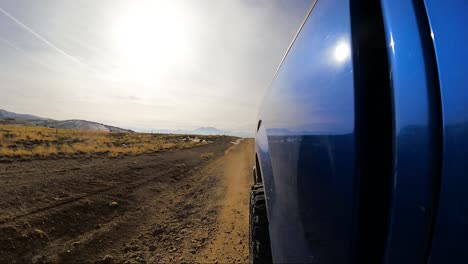 looking back along the side of a truck while driving on an off-road trail
