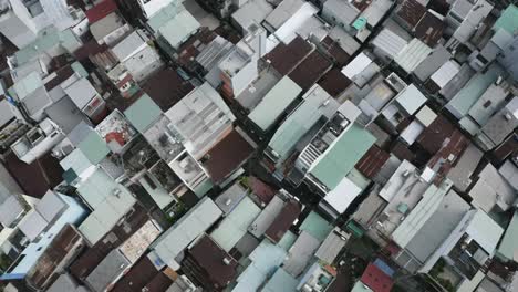 Drone-Shot-looking-straight-down-over-terrace-house-rooftops-and-narrow-alleyways-of-Binh-Thanh-Vietnam