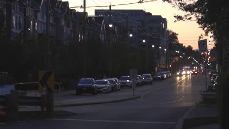 cars parked on the roadside in the city at sunset - wide shot