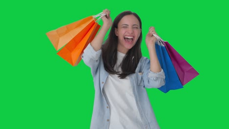 chica india feliz bailando con bolsas de compras pantalla verde