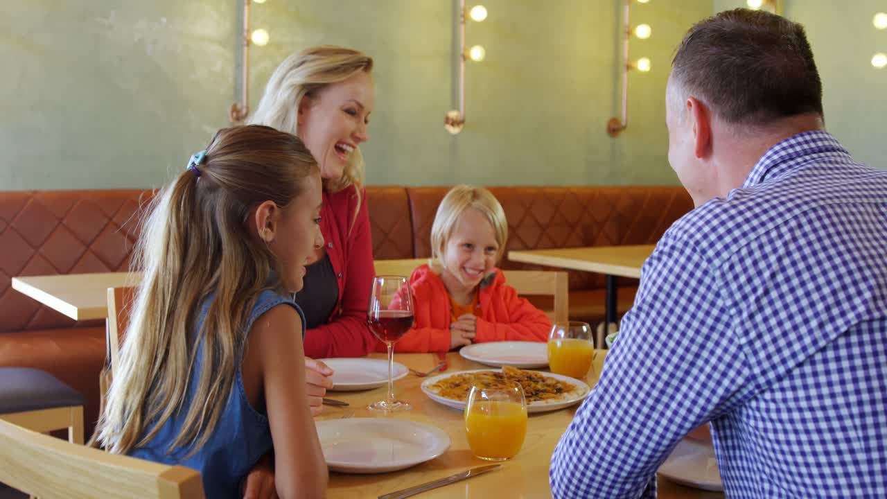 familia interactuando entre sí mientras comen 4k