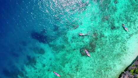 Aerial-view-of-the-coast-with-thai-longtail-boats-in-a-bright-sunny-day