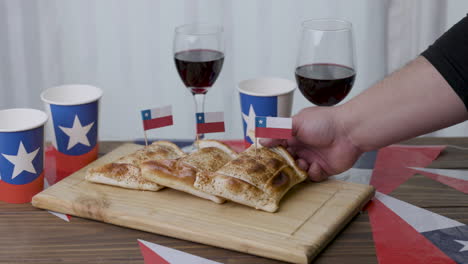 fiestas patrias chile taking out a empanada and chilean flags slow motion