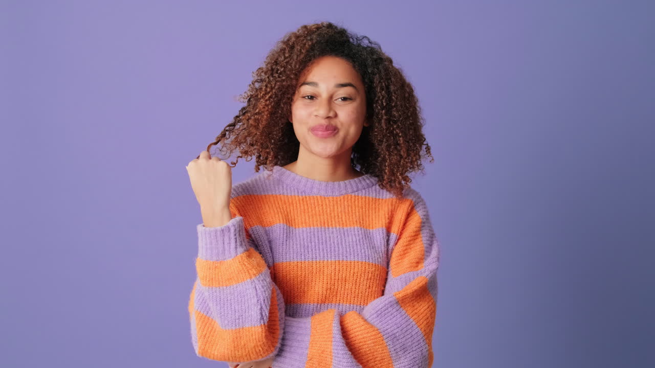 Charming Young Woman with Curly Hair Smiling and Posing Playfully