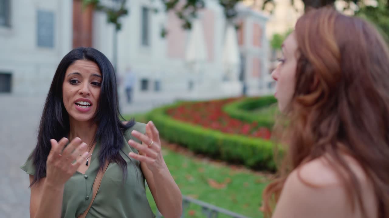 Two Women Engage in an Animated Conversation Outdoors