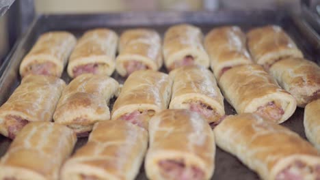 a tray of freshly baked meat-filled pastries placed on a baking sheet in a bakery