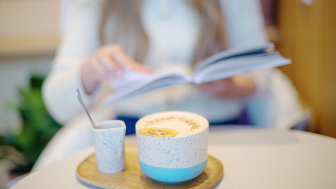 Woman reading a book at a coffee shop close up