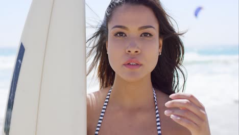 attractive female surfer posing with a board