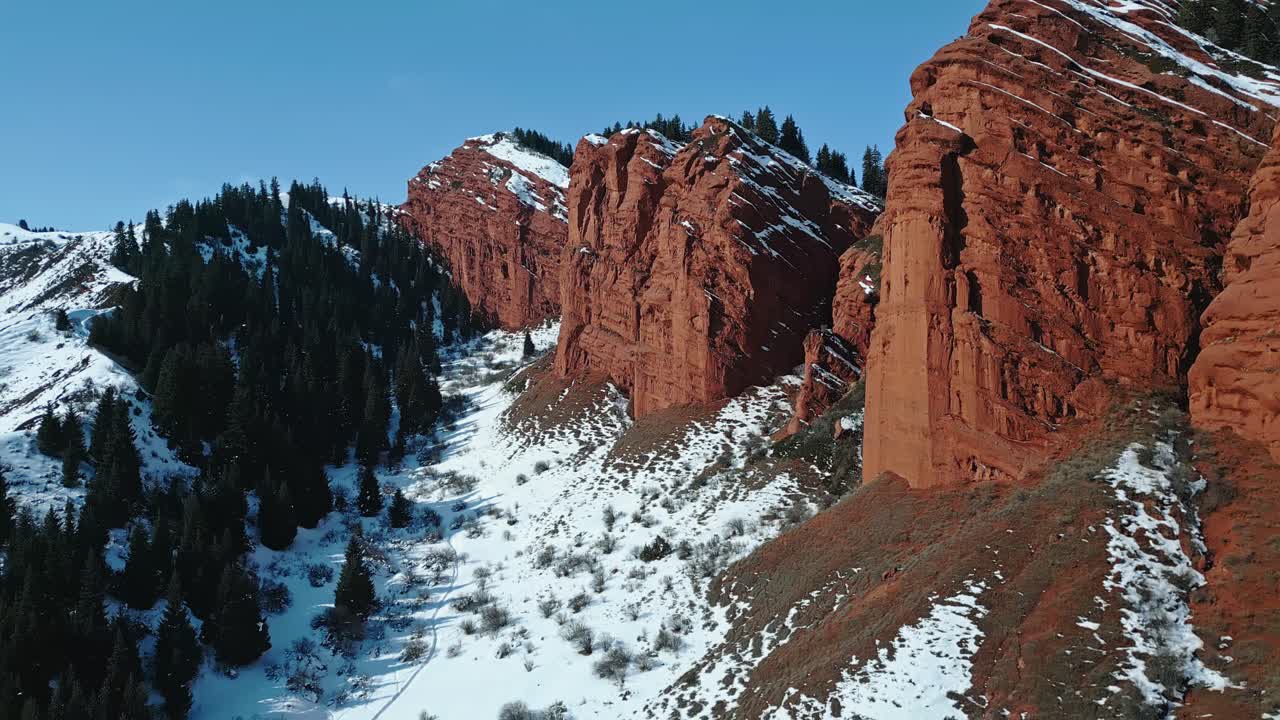 Close-up aerial reveal, weathered red rock formations, rugged landmarks