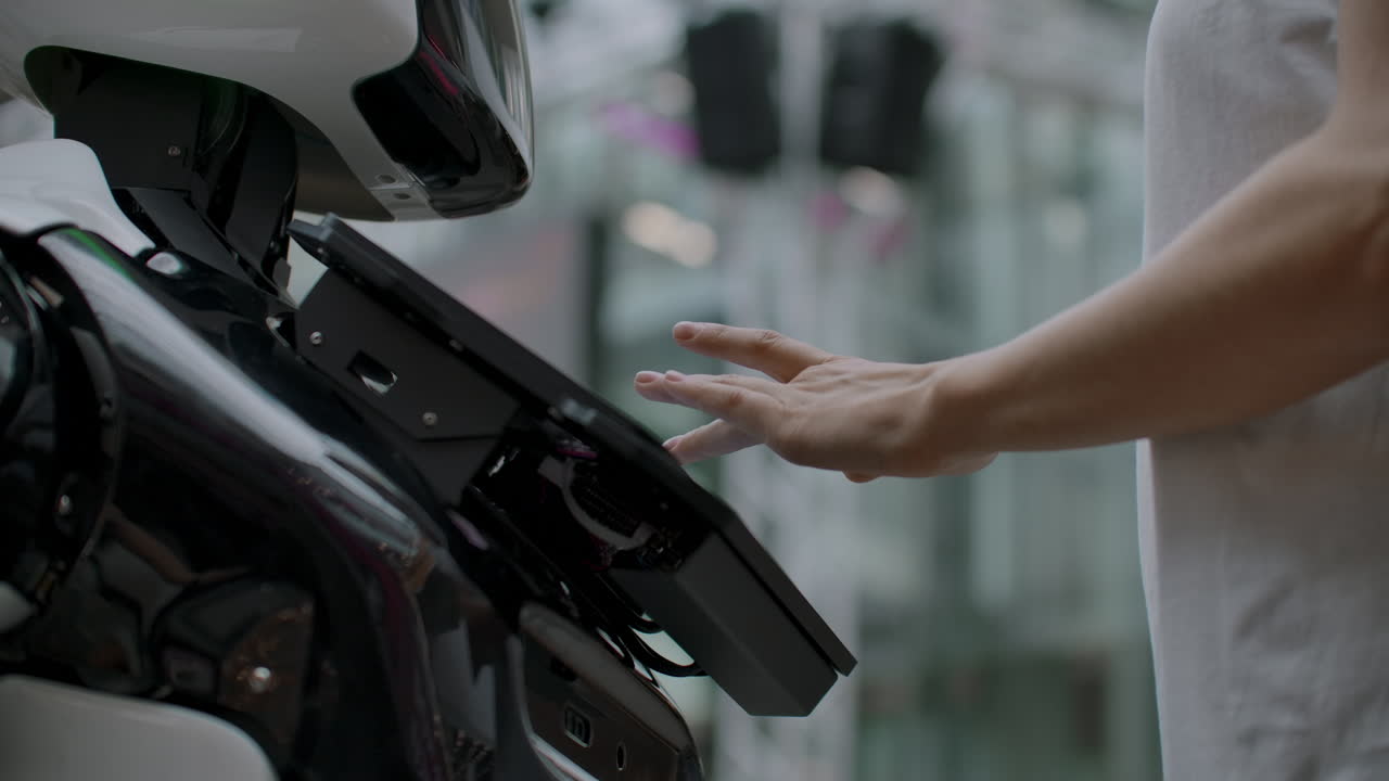 una mujer feliz en contacto con un robot cyborg. haga clic en la pantalla del robot. un droide interactúa con una mujer