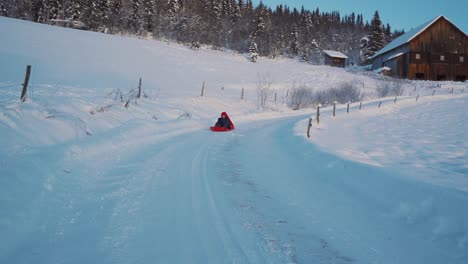 a little boy plays sledge on christmas day during winter in norway