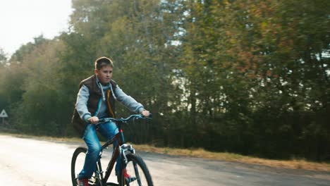 A-teenager-rides-a-bicycle-on-a-country-road