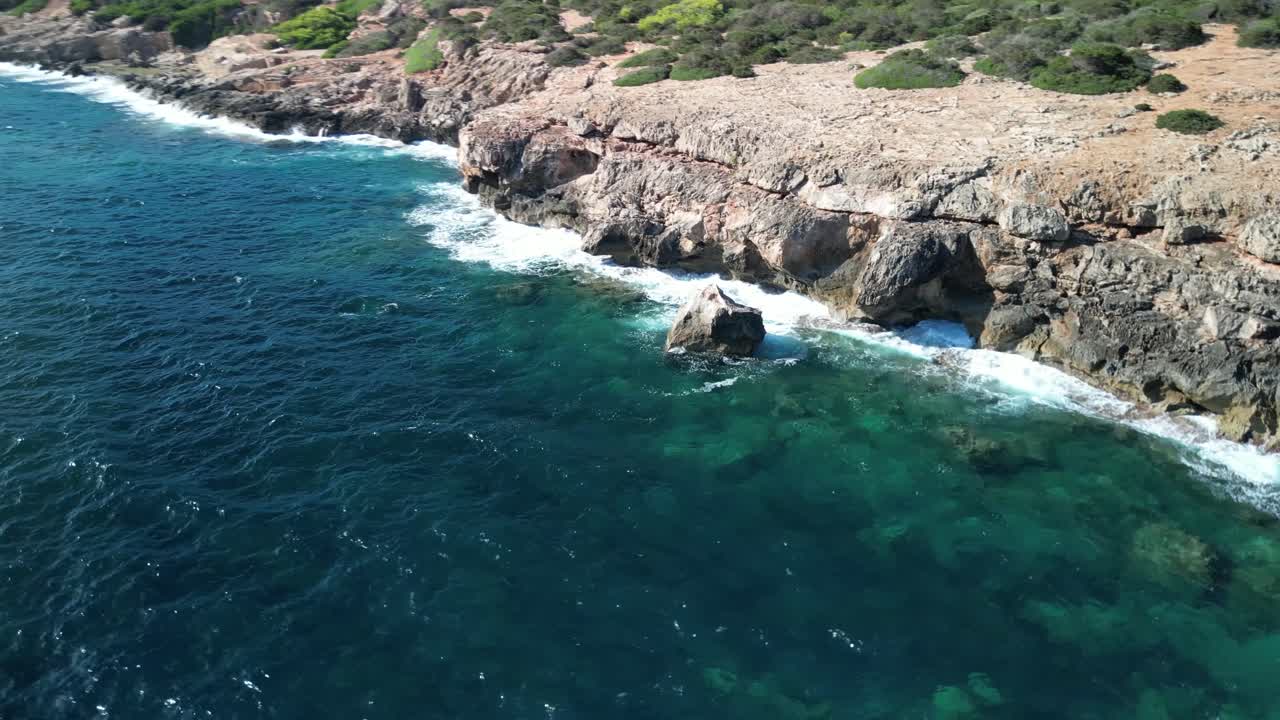 olas escénicas chocando contra las rocas en la escarpada costa cerca de sa coma en mallorca españa