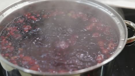 Berries-in-pot-with-boiling-water.-Cooking-compote.-Kitchen