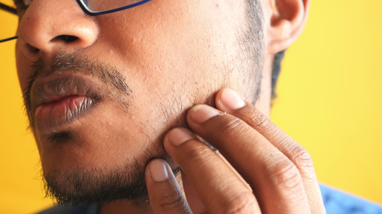 primer plano de un joven tocando su barba