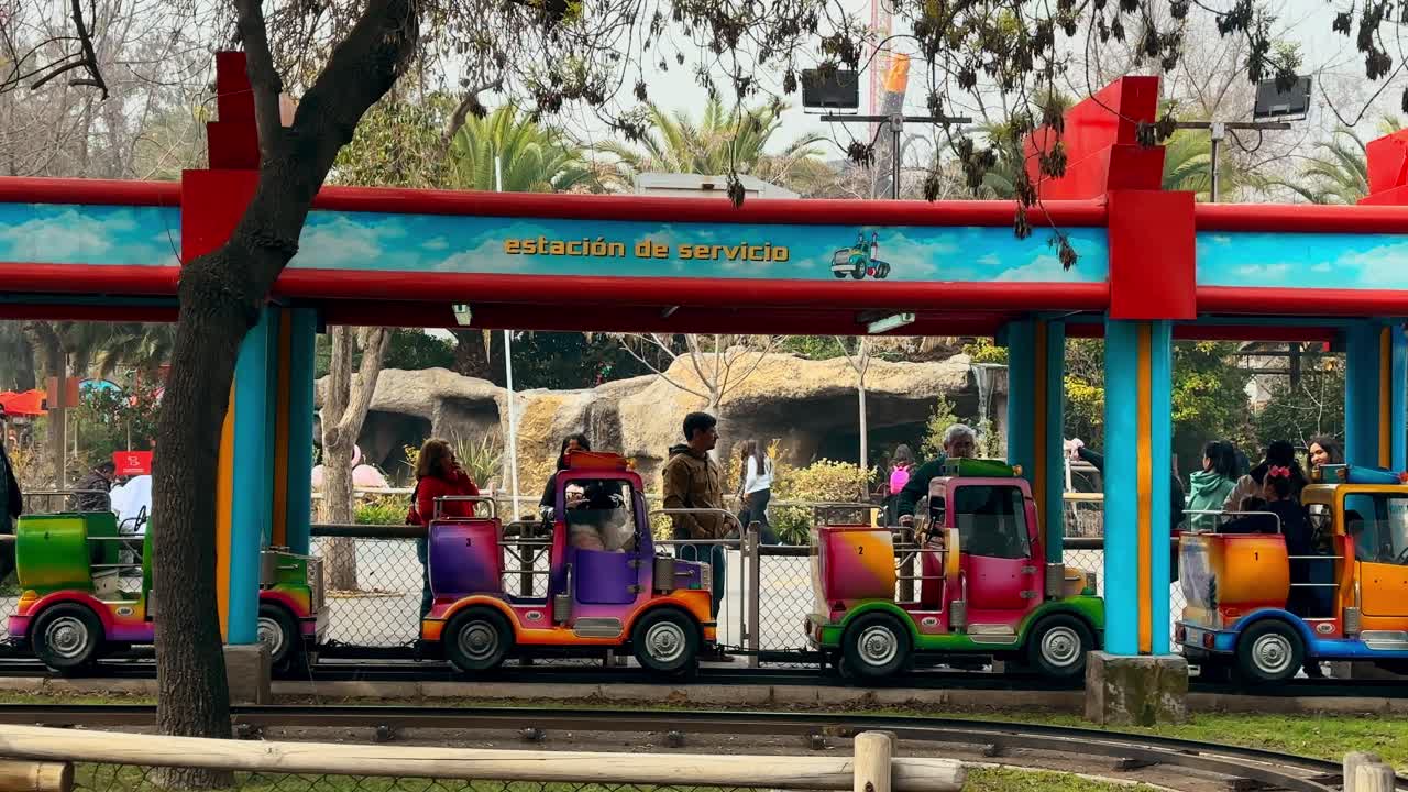 Parents looking after their children in cars at the Fantasilandia amusement park on a sunny day.