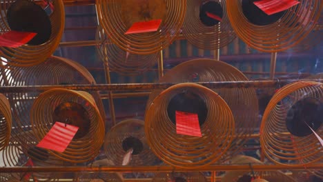 cinematic shot of circular incenses attach to the roof burning slowly and diffusing smoke-4