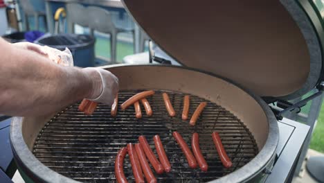 No-face-video-of-chef-putting-hot-dogs-or-sausages-in-smoker-for-grilling