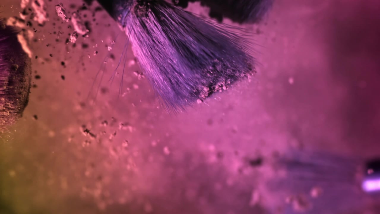 Toma macro vibrante de brocha de maquillaje dispersando polvo cosmético