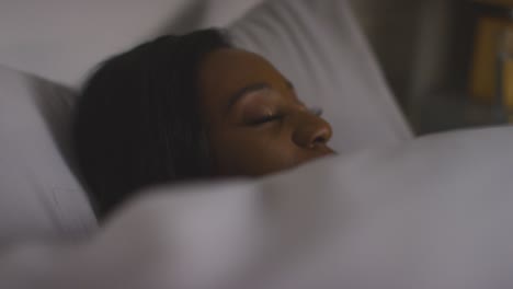 close up of woman lying asleep in bed at home at night 1