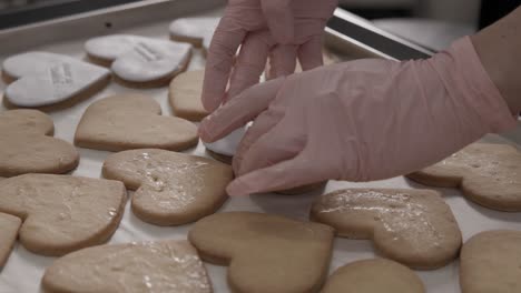 Frau-Mit-Rosafarbenen-Handschuhen,-Die-Butterkekse-Mit-Maßgefertigtem-Zuckergussblatt-Verziert,-4k-Zeitlupe