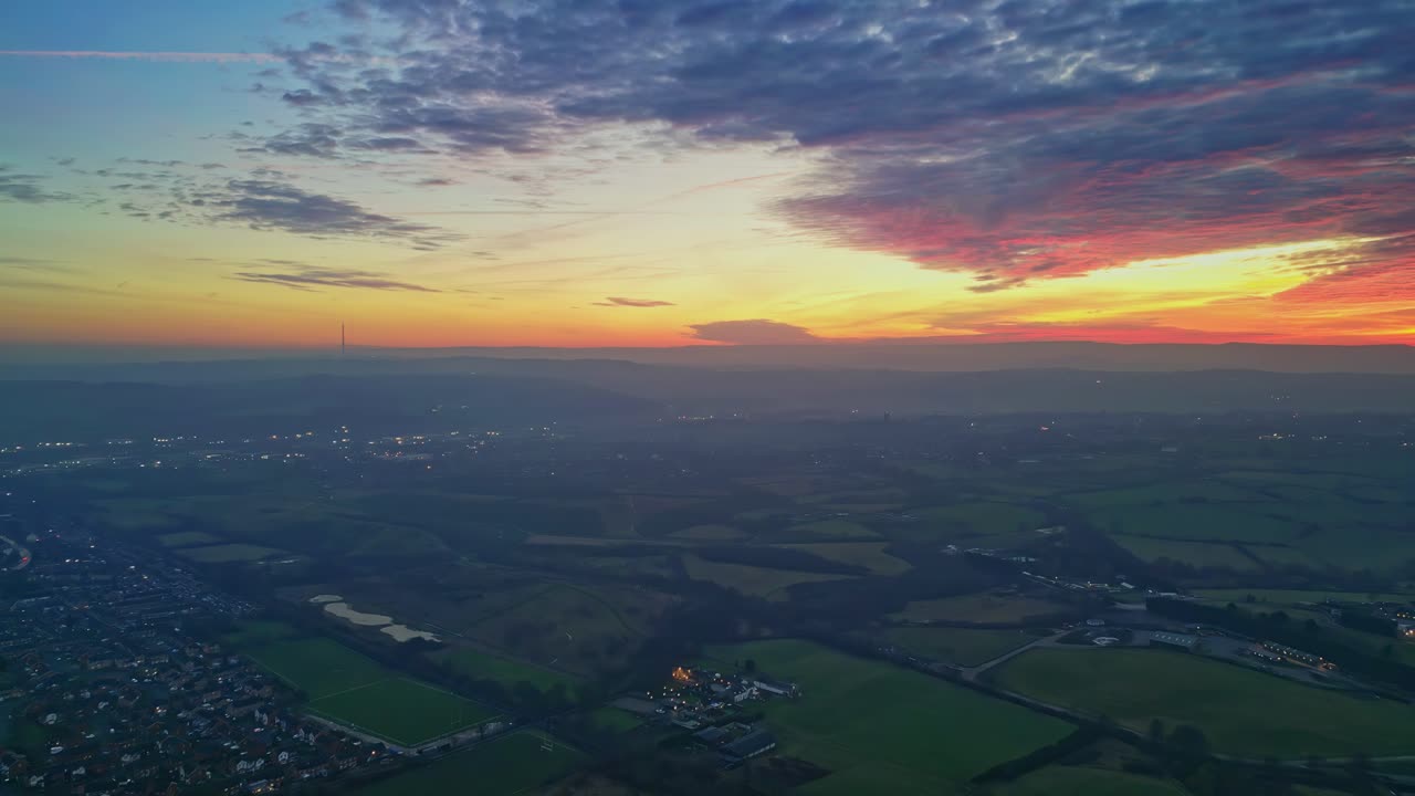 무인 항공기 영화 마을과 시골 풍경 녹색 안개 필드 다채로운 빨간색 일몰 수평선 불 구름