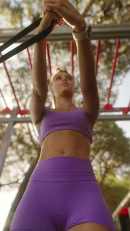 young woman doing resistance band workout outdoors