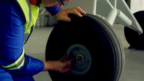 ingeniero arreglando una rueda de avión 4k