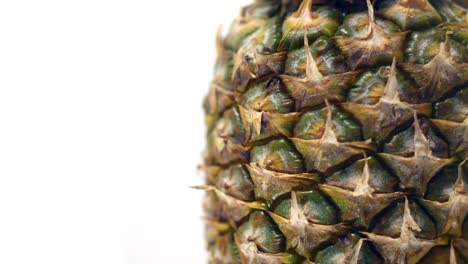 primer plano de una piña girando sobre un fondo blanco