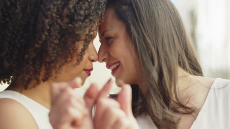 closeup shot of happy brides holding their wedding rings in front of camera and kissing