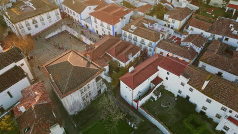 cozy suburban rooftops town buildings at evening aerial view. people walking