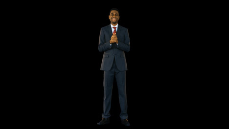 hombre de negocios de pie y sonriendo contra un fondo negro