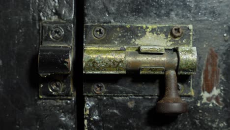 hand locking sliding old rusty door latch lock, close up