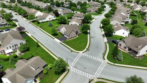 new upper class real estate houses in american suburb. noble residential area at sunny day in usa. luxury suburb of small american town. descend drone wide shot. junction in suburbia of united states