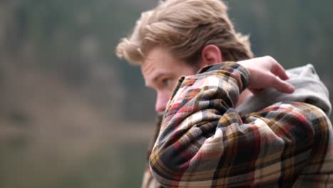 Jung-Und-Konzentriert,-So-Beschreibe-Ich-Diesen-Jungen-Mann,-Der-Selbstbewusst-Seine-Kleidung-Zurechtrückt,-Nach-Einem-Kurzen-Blick-In-Die-Kamera-Dreht-Er-Sich-Nach-Links-Und-Macht-Ein-Paar-Schritte-Nach-Vorne