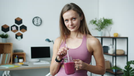 woman enjoying a smoothie in her home office