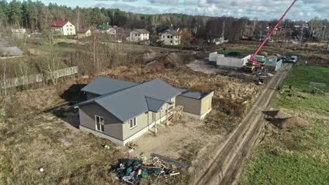 Toma-De-Drones-De-Una-Villa-De-Nueva-Construcción-Con-Trabajos-De-Construcción-En-El-Fondo