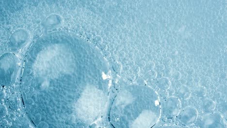 oxygen bubbles in water on a blue abstract background on super slow motion.