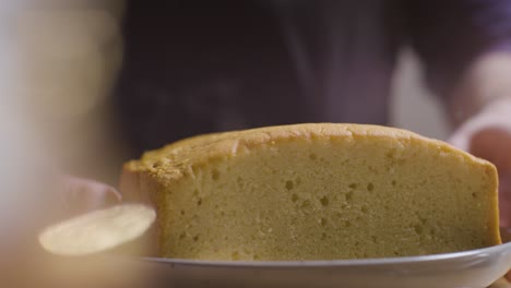 primer plano del hombre en la cocina de casa poniendo pastel recién horneado en la superficie de trabajo 1