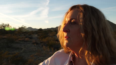 woman contemplating at sunset in the desert