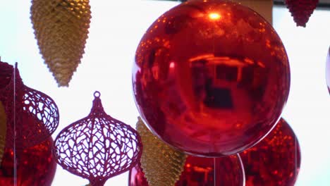 christmas and new year decoration. christmas big red balls on  background of luminous lanterns and gold garlands. holiday background. blinking garland. red baubles with lights twinkling close up.