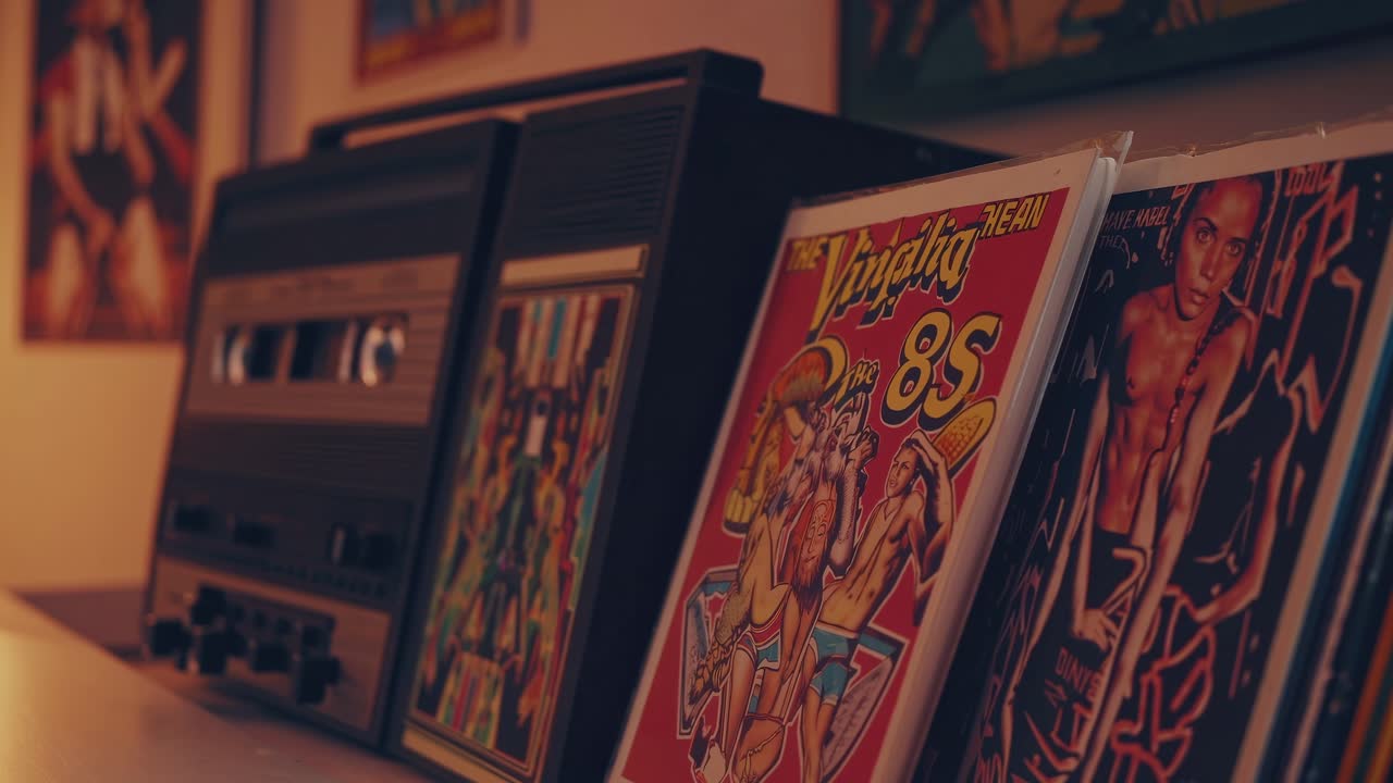 Retro audio cassette player with vibrant magazine covers displayed on a shelf, showcasing a nostalgic atmosphere and artistic decor in a cozy interior setting