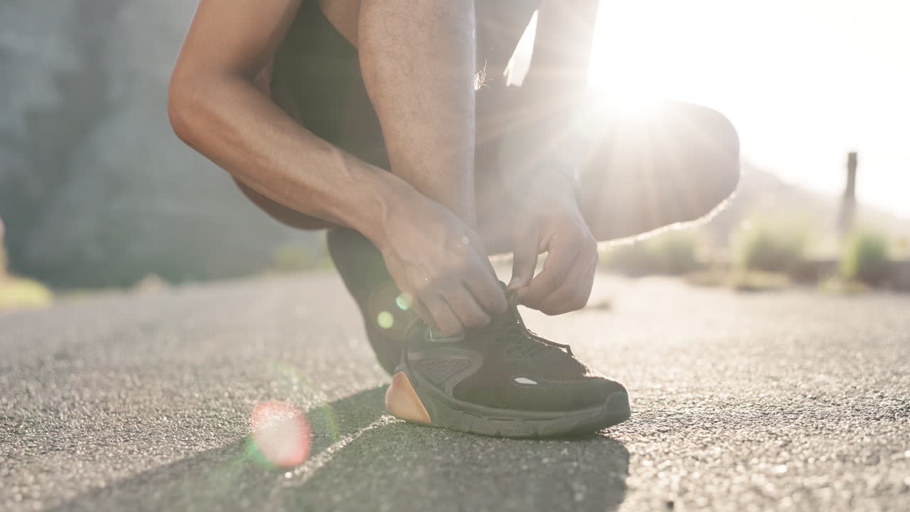 Fitness, uomo e mani che allacciano le scarpe in preparazione