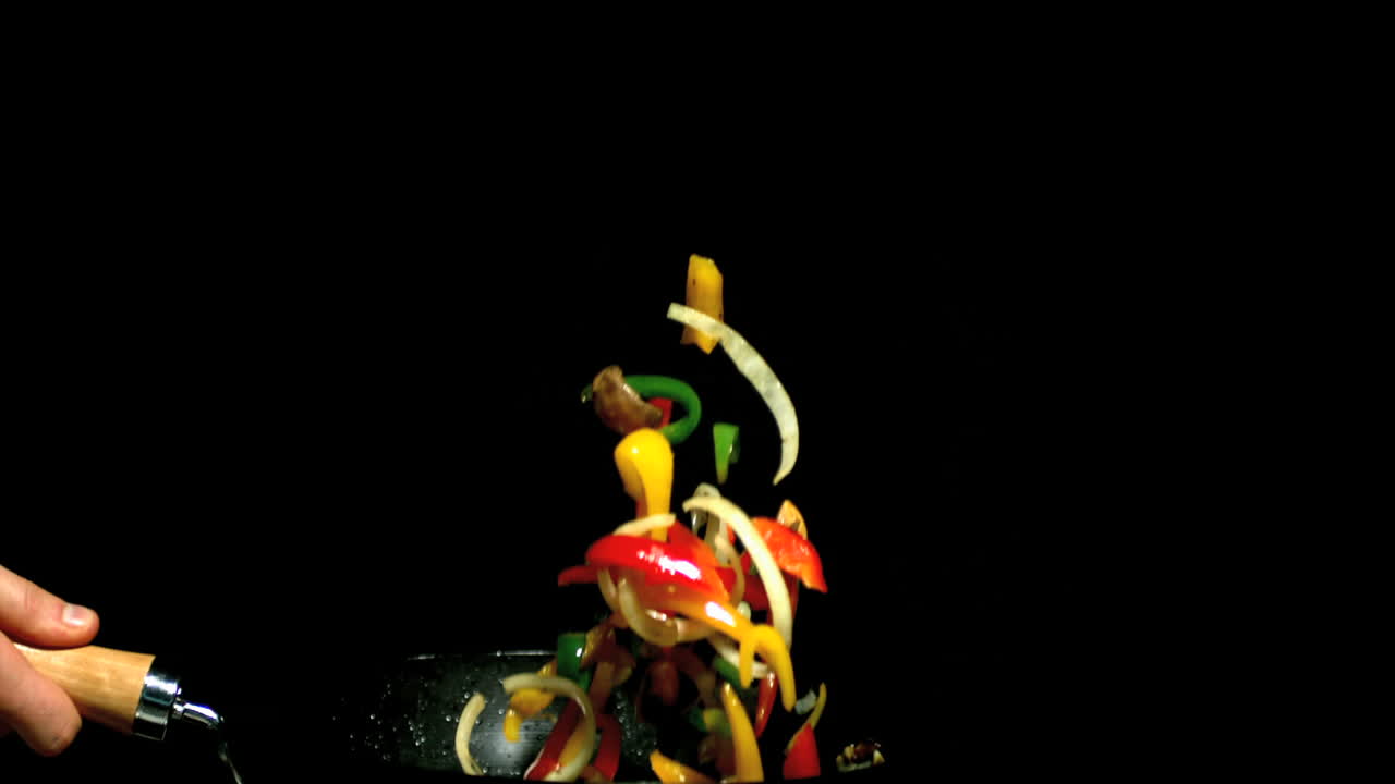 chef lanzando verduras en el wok vista lateral