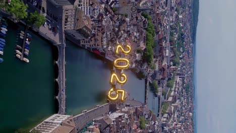 vista aérea del horizonte de la ciudad de zúrich y los brillantes números 2025 sobre el río