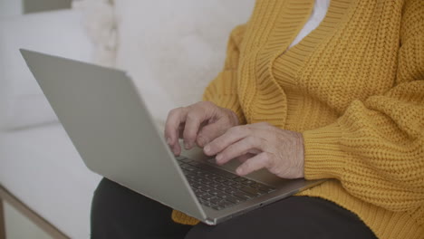 Joyful-caucasian-lady-finishing-a-project.-Happy-mature-woman-working-her-laptop-ending-her-at-home-during-self-isolation.